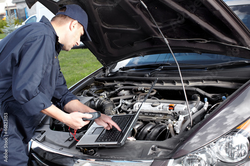 Photo: Car mechanic working in auto repair service. Car mechanic working in auto repair service.