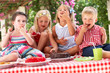 Group Of Children Eating Jelly And Cake At Outdoor Tea Party