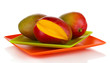 Ripe appetizing mango on red plate isolated on white
