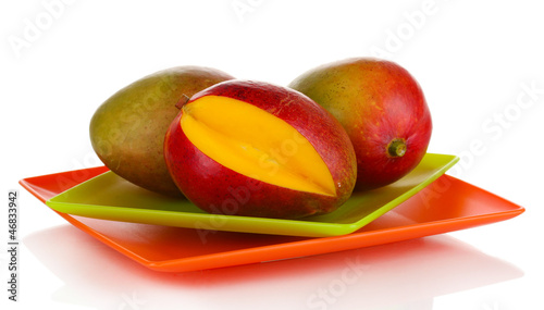 Photo: Ripe appetizing mango on red plate isolated on white Ripe appetizing mango on red plate isolated on white