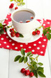 cup of tea with hip roses, on wooden table