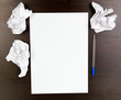 empty paper, crumpled paper and pen on wooden table