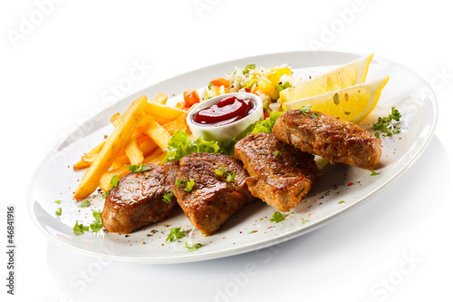 Photo: Grilled steaks, French fries and vegetables Grilled steaks, French fries and vegetables