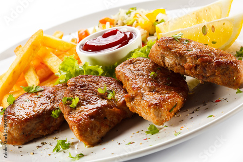 Photo: Grilled steaks, French fries and vegetables Grilled steaks, French fries and vegetables