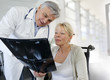 Surgeon showing X-ray result to woman in wheelchair
