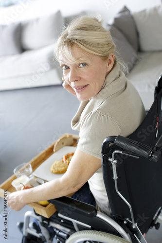 Photo: Senior woman in wheelchair holding lunch tray Senior woman in wheelchair holding lunch tray