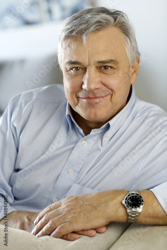 Photo: Portrait of senior man relaxing in sofa at home Portrait of senior man relaxing in sofa at home