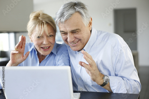 Photo: Senior couple connected with family on internet Senior couple connected with family on internet
