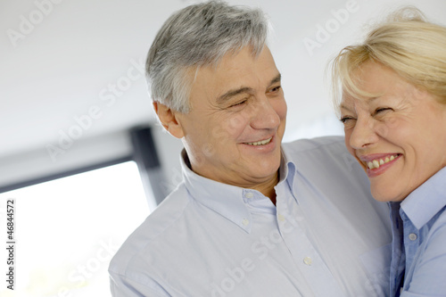 Photo: Portrait of cheerful senior couple at home Portrait of cheerful senior couple at home