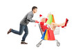 Happy guy pushing a female wearing christmas costume in a cart