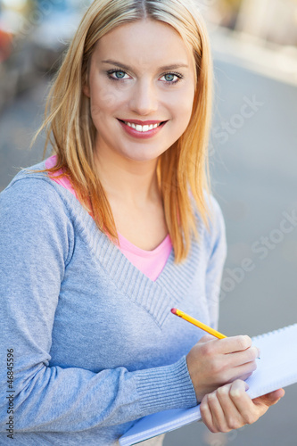 Photo: Young woman with notebook and pencil Young woman with notebook and pencil