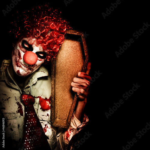 Photo: Evil Horrible Clown Holding Coffin In Darkness Evil Horrible Clown Holding Coffin In Darkness