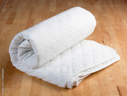 Photo: white mattress protection on wooden background white mattress protection on wooden background