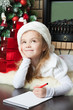 Funny girl in Santa hat writes letter to Santa