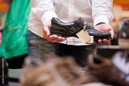 Photo: Mann kauft Schuhe im Supermarkt Mann kauft Schuhe im Supermarkt
