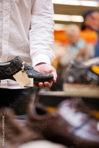 Photo: Mann kauft Schuhe im Supermarkt Mann kauft Schuhe im Supermarkt