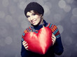 Lovely girl in sweater with toy heart.