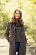 Style redhead girl at beautiful autumn alley.