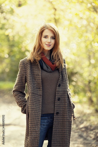 Photo: Style redhead girl at beautiful autumn alley. Style redhead girl at beautiful autumn alley.