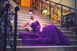 woman in a long dress is sitting on the stairs