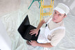Painter holding laptop computer