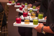 Servers holding colored shot glasses