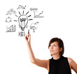 Young business woman drawing light bulb with various diagrams an