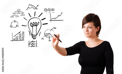 Photo: Young business woman drawing light bulb with various diagrams an Young business woman drawing light bulb with various diagrams an