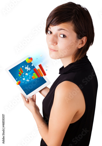 Photo: Young woman looking at modern tablet with colourful diagrams Young woman looking at modern tablet with colourful diagrams