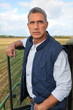 Farmer stood by tractor