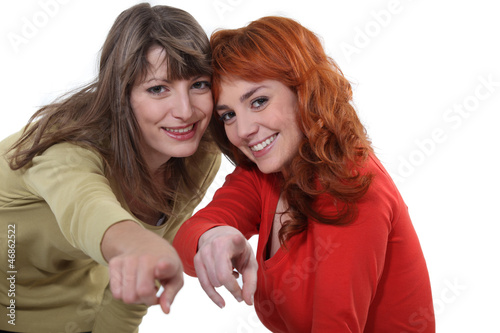 Photo: Two female friends pointing at the camera Two female friends pointing at the camera