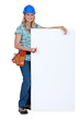 Female construction worker with a blank board