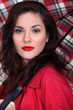 Brunette holding umbrella indoors