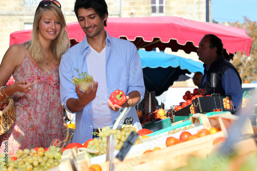 Photo: Young couple at a market stall Young couple at a market stall