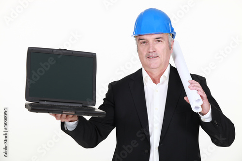 Photo: A mature architect with a laptop. A mature architect with a laptop.