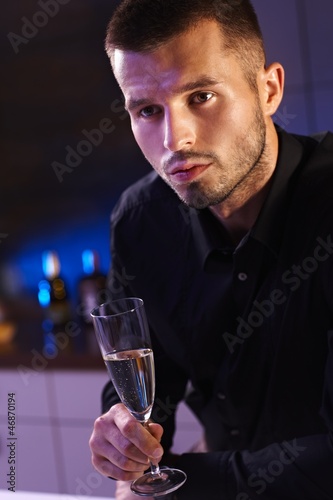 Photo: Evening portrait of young man with champagne flute Evening portrait of young man with champagne flute