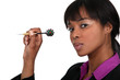 A businesswoman playing darts.