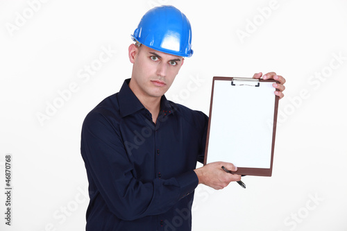 Photo: Manual worker stood with clip-board and pen Manual worker stood with clip-board and pen