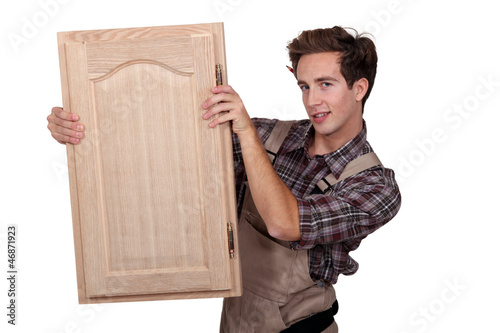 Photo: A carpenter holding a closet door. A carpenter holding a closet door.