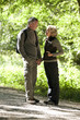 A mature couple standing under a tree holding hands