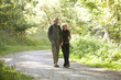 A mature couple walking along a country path holding hands