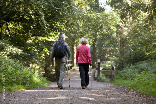 Photo: A mature couple walking along a country path, rear view A mature couple walking along a country path, rear view