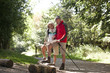 A mature couple standing on a country path, looking at a map