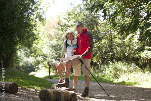 Photo: A mature couple standing on a country path, looking at a map A mature couple standing on a country path, looking at a map