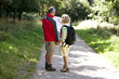 A mature couple walking in the countryside, holding a map