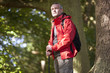 A mature man standing in woodland