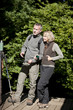 A mature couple looking at a map on an ipad in the countryside
