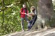 A mature couple standing in woodland looking at a map