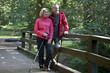 A mature couple standing on a footbridge in the countryside