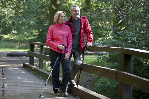 Photo: A mature couple standing on a footbridge in the countryside A mature couple standing on a footbridge in the countryside